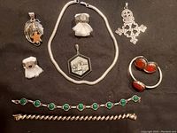 Image showing all 10 sterling silver jewelry pieces arranged on black background including pendants, bracelets, earrings, rings, and necklace as described by seller.