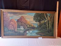 Large horizontal oil painting in wooden frame showing river landscape with swans, stone benches, and forested background.