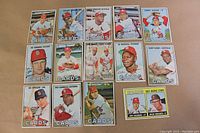 Photo showing fronts of all 14 Topps 1967 St. Louis Cardinals cards featuring various players including Orlando Cepeda, Tim McCarver, Curt Flood, Card's Clubbers, Ed Spiezio, Pat Corrales, Larry Jaster, and a dual rookie card of Jim Cosman & Dick Hughes.