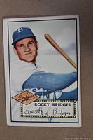Front color illustration of Rocky Bridges in Dodgers uniform holding a bat.