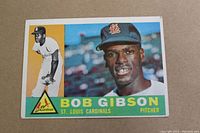 Front view of 1960 Topps Bob Gibson card showing portrait, action photo, and St. Louis Cardinals logo.
