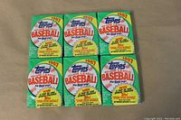 Front view of six unopened 1987 Topps Major League Baseball wax packs arranged in two rows of three.