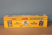 Photo of the 1990 Score Baseball factory sealed collector set yellow box, showing front with number of cards and player card images.