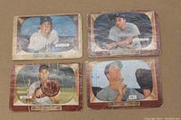 Front view of 4 1955 Bowman baseball cards showing players Matt Batts, Lou Boudreau, Alex Kellner, and Gus Bell framed inside TV screen graphics