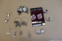 Full lot overview showing 8 pairs of costume earrings of various designs