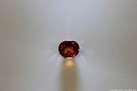 Close-up of the orange sapphire loose gem showing color and cut.