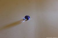 Close-up photo of loose oval cut blue sapphire gemstone showing vivid blue color and clarity.