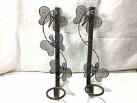 Front view of the pair of black metal butterfly wall hangings with holders for mini pots