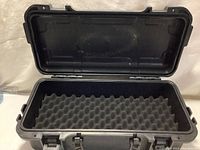 Open Bushnell Pelican style hard case showing convoluted foam padding inside for equipment protection.