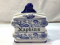 Front and top view of white ceramic napkins holder with cobalt blue floral and onion underglaze pattern and 'Napkins' text.