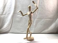 Front angle showing the manikin posed with arms and one leg lifted.