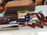 Overview of all boxes, knives and sheaths laid out on table