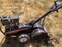 Side view of Craftsman rototiller with Dual Rotating Tines label and gas engine, showing wear and soil residues.