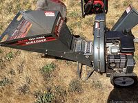 Side view of shredder showing hopper, engine, discharge chute and wheels