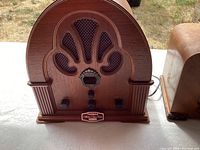 Front view of Thomas Collector’s Edition Model BD109 radio showing arched wood case, grille design and control knobs