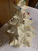Full view of the ceramic Christmas tree with various colored bulbs attached.