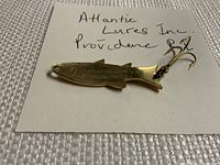 Close-up of the fishing lure showing engraved brand and hook