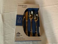 Box front showing 20-piece set including knives, forks, and spoons in a blue and white Hampton Forge package.