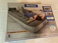 Front view of the Bestway twin air mattress box showing the mattress image and built-in pump feature with dimensions 74" L x 39" W x 12" H.