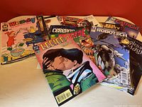 Photo showing multiple comic books including Wendy the Little Witch, Legion of Super-Heroes, Robotech, Cerebus, Catfight, and others.