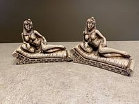 Front view of both reclining Egyptian queen bookends on cushions, showing detailed facial features, attire and posture.