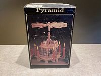Box featuring image of wooden nativity windmill carousel with candle holders