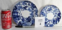 Two blue and white plates side by side with a Coca-Cola can for scale. Larger plate 7.25 inches diameter on left, smaller 6.25 inches on right. Both feature detailed scenic designs typical of Royal Crown Derby Mikado pattern.