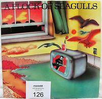 Front cover of A Flock Of Seagulls self titled vinyl LP showing surreal artwork with TV, window, and seagulls.