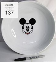 Top-down view of the white ceramic serving bowl with a black and white Mickey Mouse face on the inside bottom. Shows diameter size with Sharpie pen for scale.
