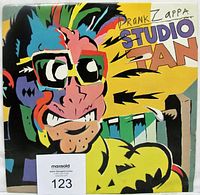Front colorful cartoon-style illustrated jacket of Frank Zappa Studio Tan LP album with wear visible along edges and corners. Includes MaxSold auction label.