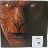 Close-up photo of the Eye Of The Zombie album cover showing the animal face artwork with yellow eyes and brown textured face, with an auction number card '70' attached.