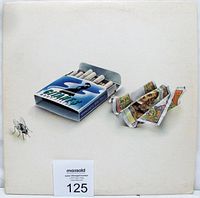 Front cover of the Go Live From Paris double vinyl album showing stylized pack of cigarettes, a fly, and crumpled currency.