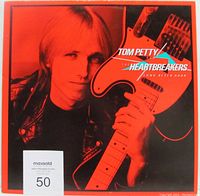 Front cover of the vinyl record sleeve showing Tom Petty holding a guitar with orange tint.