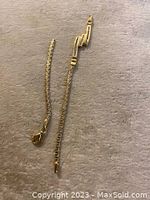 Full view of bracelet laid flat showing broken chain and separated clasp