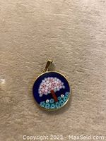 Front view of round micro mosaic pendant showing tree design and gold frame