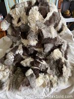 Overall view of fur throw blanket draped over surface, showing patchwork fur colors and texture.
