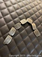 Overall view of the pewter bracelet laid flat on a quilted surface showing all links and clasp.