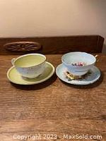 Photo showing two bone china cups and matching saucers, one set in light green and the other in pale blue with floral designs.