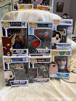 Overview photo showing six Funko Pop figures in original boxes: Batman Man Bat #189, Aquaman Black Manta #248, Sherlock Holmes with Violin #289, Family Guy Peter Griffin #31, Tekken Armor King #207, John Wick #387.