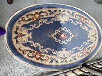 Full view of oval wool rug showing overall pattern and colors.