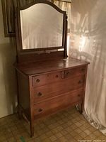 Full view of antique wood dresser with swivel mirror, showing front and side details