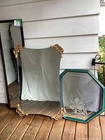 Three mirrors displayed against a white wall and wooden floor, showing size and frame styles