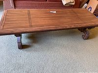 Top view of the large rectangular wooden coffee table showing the wood grain and carved inset details on the tabletop.