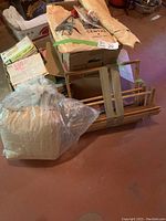 Lot showing wooden folding loom packed with miscellaneous sewing items in cardboard boxes and plastic bag