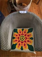 Top view of light green wicker chair with floral cushion in seat