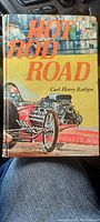 Front cover of 'Hot Rod Road' hardcover book showing title, author and colorful hot rod artwork