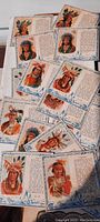 Photo shows multiple collector cards fanned out. Front sides of cards display colorful illustrations of American Indian chiefs wearing various headdresses and traditional attire with border.
