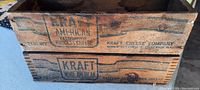 Close-up photo showing the printed Kraft Cheese Company advertising on the side of one wooden box.