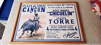 Full view of framed bullfight poster showing artwork, event details, and artist signature.