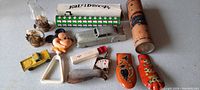 Wide view of vintage collectible items including two kaleidoscopes, small metal vehicles, Mickey Mouse rattler toy, Halloween clogs, and other small toys
